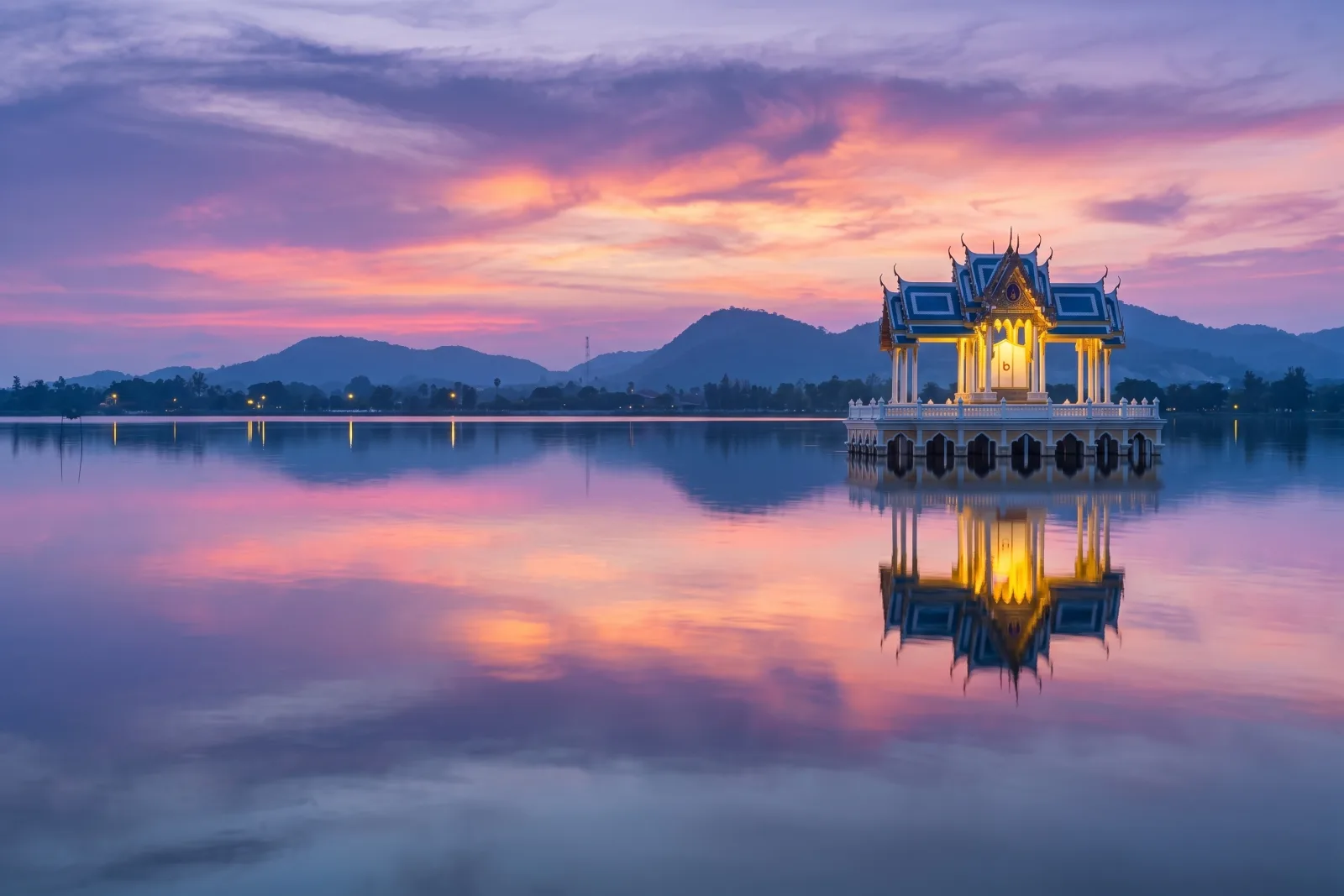 Lakeside temple pavilion reflected at sunset near Khao Tao